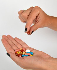  Woman holding different kind of pills in her hand