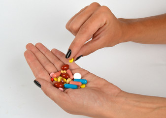  Woman holding different kind of pills in her hand