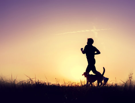 Runner with dog silhouettes at the sunset