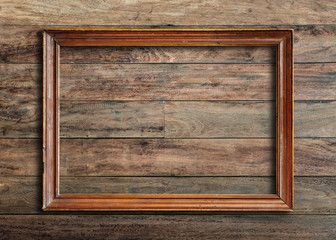Old picture frame on vintage wood wall.