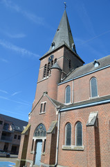Fototapeta na wymiar Brick church tower against blue sky