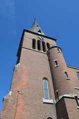 Brick church tower against blue sky