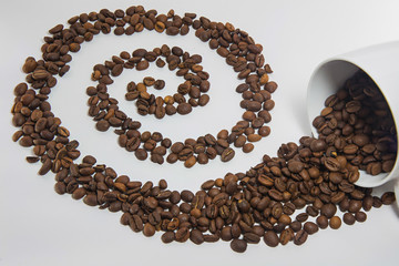 Spilled coffee beans from the white ceramic cup a beautiful patt