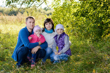 Naklejka na ściany i meble Family resting the meadow in autumn