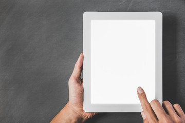 hands holding and touching the screen of tablet with white blank