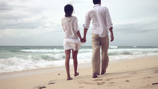Happy couple in love having fun on the beach, slow motion,