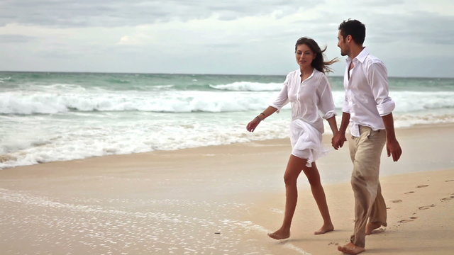Happy couple in love having fun on the beach, slow motion,