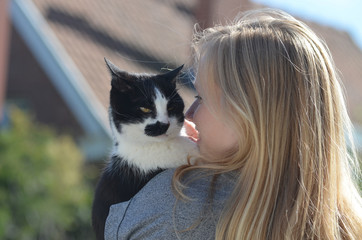 Girl hugging with black and white cat