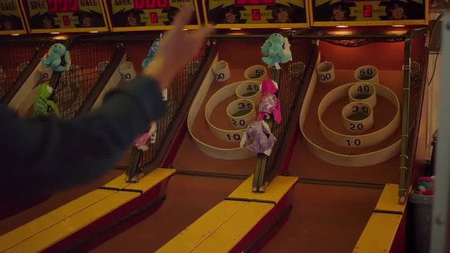 Someone scoring high points in skee ball
