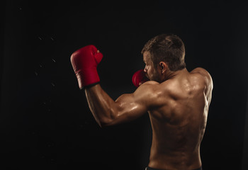 Athletic bearded boxer with gloves on a dark background - 90699497