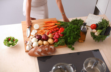 Young woman cutting vegetables in the kitchen