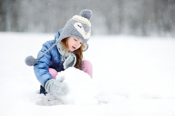 Funny little girl having fun in winter park