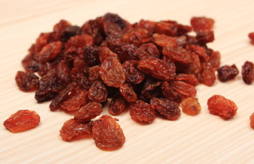 Brown raisins on wooden table, healthy eating