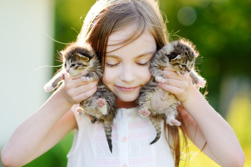 Adorable little girl playing with small kittens © MNStudio