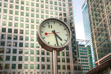 Fototapeta na wymiar LONDON, CANARY WHARF UK - MARCH 2, 2015: Modern architecture of Canary Wharf business aria and clock on the main square