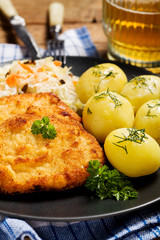 Fried pork chop in breadcrumbs, served with boiled potatoes and