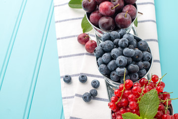 Plums, red currants and blueberries in small metal bucket