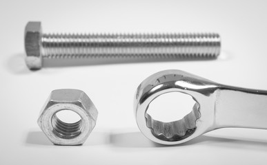 Screw, nut, wrench isolated on white