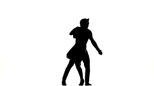 Two latino dancers in action, silhouette, on white