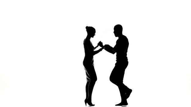 Two latino dancers finishing dancing, silhouette, on white