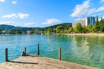 Wooden pier along Worthersee lake shore in summer season, Austria