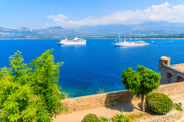 View of cruise ships mooring on blue sea in Calvi bay, Corsica island, France