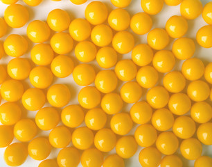 Yellow round pills, as vitamins on white background.