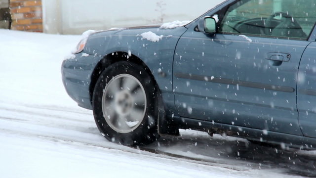 Car Struggles and Slides Up Hill in Snow Storm Icy Roads