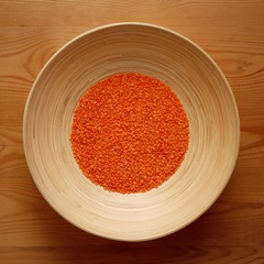 Bamboo Bowl with Red Lentil on Wood Background