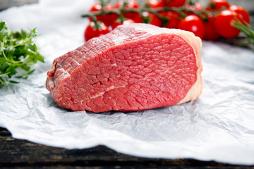 a pieces of fresh meat, beef slab, decorated with greens and vegetables