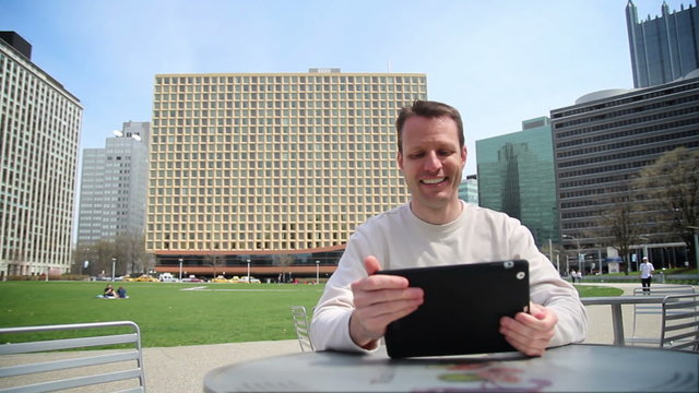 Man Using Tablet PC in an Outdoor Cafe