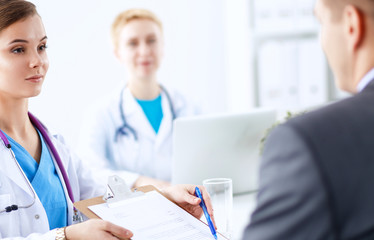 Medical team sitting at the table in modern hospital