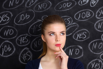 Thinking young woman with yes or no choice on gray background