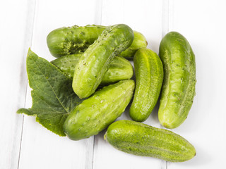 fresh organic cucumbers on a white wooden background.