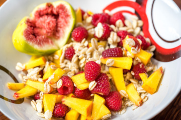 Naklejka na ściany i meble cereal flakes with fresh berries and fig in a plate for breakfast, close-up