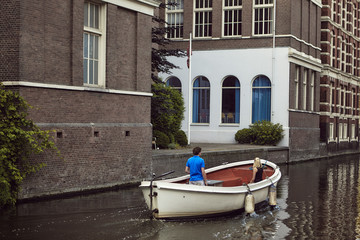 casal a passear de barco branco em canal em Amsterdão