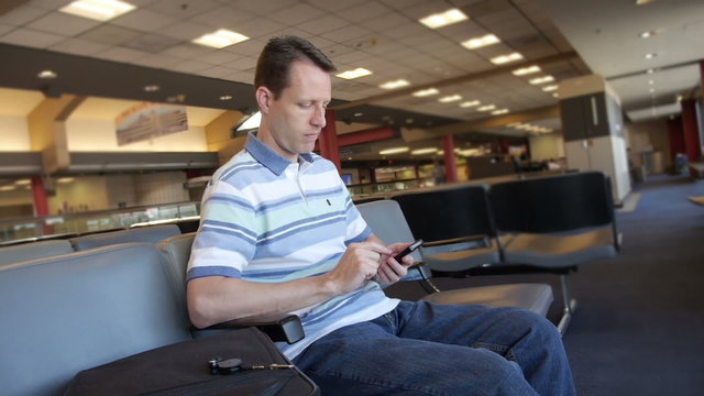 Man at Airport with Smartphone