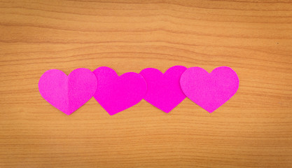 pink heart on wood background.