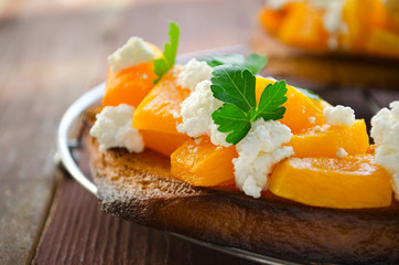 Bruschetta with chunks of pumpkin, goat cheese and parsley