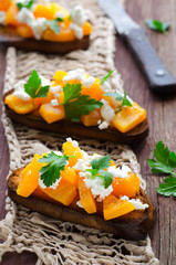 Bruschetta with chunks of pumpkin, goat cheese and parsley