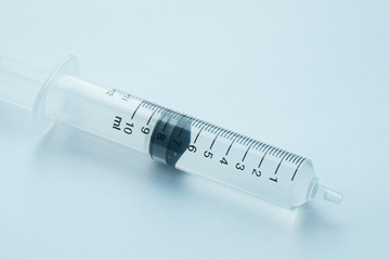 syringe with clear liquid on light background