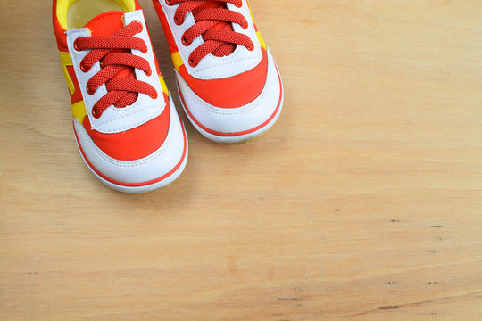 Picture of a pair of kids sport shoes on wood board