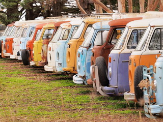 Row of defunct colorful and run down desolate vans of all the same Bully type, Australia 2016