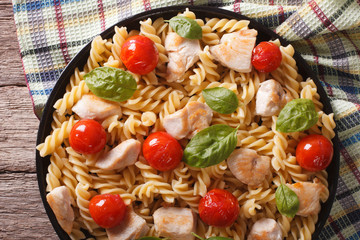 fusilli pasta with chicken, tomatoes and basil closeup. horizontal top view
