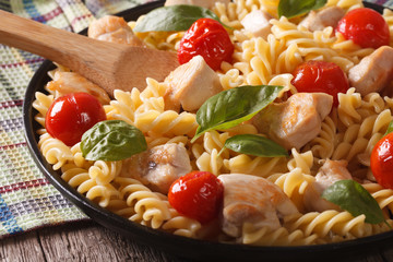 fusilli pasta with chicken and tomatoes close-up. horizontal
