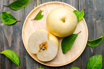 Fresh Asian pear on wooden plate