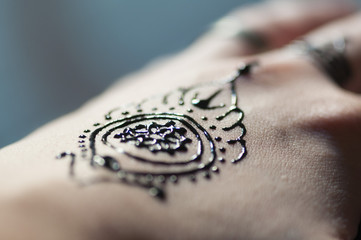 Henna tatoo painted on hand with black ink