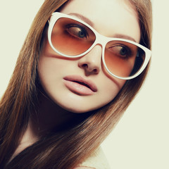 Beautiful young model with big sunglasses, close up, image toned