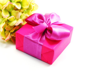 pink present on white background with ribbon and beautiful flower