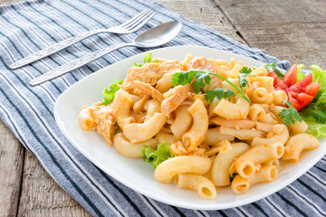 fried macaroni with sausage in plate placed on a wooden table